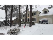 Charming two-story traditional home with black shutters and attached garage covered in fresh snow at 180 Shyrewood Dr, Lawrenceville, GA 30043