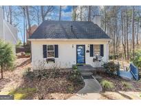 Charming exterior featuring a quaint cottage with a blue door, and landscaped front walkway at 1533 Park Creek Ne Cv, Atlanta, GA 30319