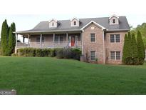 Inviting two-story brick home with covered porch and well-manicured lawn at 195 Twin Oaks Dr, Hampton, GA 30228