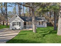 Charming renovated home featuring a cozy front porch, fresh paint, and well-maintained landscaping at 9317 Thomas Rd, Jonesboro, GA 30238