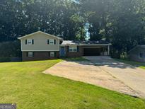 Charming two-story home with brick accents, attached carport, and a spacious front yard at 3859 Rosedale Ln, Douglasville, GA 30135