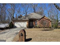 Charming brick home featuring a well-manicured lawn, two-car garage and inviting front entrance at 2779 Knollview Dr, Decatur, GA 30034