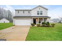 Charming two-story home with a well-manicured lawn and an attached two-car garage at 415 Arthurs Ln, Covington, GA 30016
