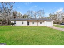 Charming single-story home with a well-maintained lawn and attached garage at 430 Birch Se Ln, Conyers, GA 30094