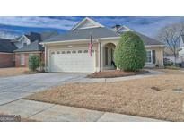 Charming home with attached two-car garage, well-manicured lawn, and manicured shrubbery at 106 Prestwick S Way, Stockbridge, GA 30281