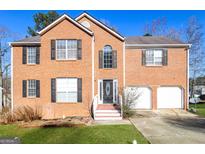 Charming two-story brick home with a well-maintained lawn and a two-car garage at 1015 Crooked Creek Rd, Lithonia, GA 30058