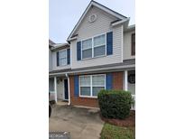 Charming townhome featuring brick accents, blue shutters and neutral siding at 5338 Creekview Ln, Morrow, GA 30260