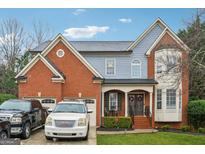 Attractive brick and siding home with a well-maintained front yard and driveway at 2633 Back Creek Chase, Dacula, GA 30019