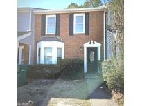 Charming brick townhome featuring a decorative front door and bay window at 8053 Woodlake Dr, Riverdale, GA 30274
