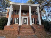 Classic two-story brick home with black shutters and stately white columns on the front porch at 1241 Mount Vernon Dr, Lawrenceville, GA 30044