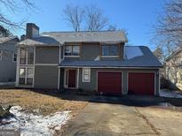 Two-story home with a red two car garage and gray trim on a sunny day at 1124 Empire Cir, Lawrenceville, GA 30044