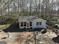 Cozy home featuring mature trees, a walkway, and an inviting front porch at 573 Stagecoach Rd, Stockbridge, GA 30281