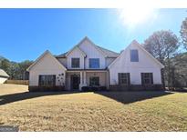 An inviting home showcasing a combination of stone, siding, and shuttered windows at 34 Brittany Way, Palmetto, GA 30268