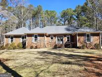 Charming brick home featuring a well-manicured front yard and complemented by beautiful mature trees at 170 Royal Ridge Way, Fayetteville, GA 30215