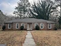 Charming brick home featuring a well-maintained lawn and mature trees at 676 Bralorne Dr, Stone Mountain, GA 30087