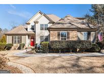 Beautiful two-story home with stone and wood accents, a circular driveway, and a manicured front lawn at 6 Water Oak Dr, Sharpsburg, GA 30277