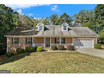 Charming brick home featuring an attached garage and inviting front porch at 225 Chinns Way, Hampton, GA 30228