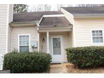 Cozy home exterior featuring a well-kept lawn and charming front door, creating a welcoming appeal at 6434 Wellington Chase Ct, Lithonia, GA 30058