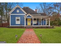 Charming blue two-story home with a brick walkway leading to a welcoming yellow door at 85 Bryan St, Mcdonough, GA 30253