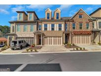 Beautiful townhomes feature brick and stone accents, with a two car garage and manicured landscaping at 118 Via Roma, Woodstock, GA 30188