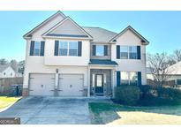 Charming two-story home featuring a two-car garage and well-maintained lawn at 611 Winners Cir, Locust Grove, GA 30248