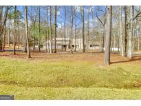 Secluded home nestled among trees featuring beautiful front lawn and neutral siding at 106 Robinson Bend Trl, Peachtree City, GA 30269