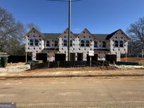 New construction townhomes showcase a modern design and the initial stages of exterior construction on a sunny day at 11608 E Lovejoy Rd # 7, Hampton, GA 30228