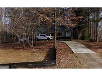 Suburban home with long driveway and white pickup truck in the front yard at 24 Picketts Mill Pl, Acworth, GA 30101