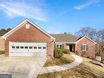 Charming brick home with a well-maintained lawn, curved walkway, and attached two car garage at 1280 Pinyon Pl, Lawrenceville, GA 30043