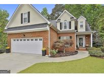Charming two-story brick home with an attached two-car garage and well-manicured lawn at 115 Ashton Park, Peachtree City, GA 30269