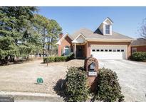 Charming red brick home featuring an attached two car garage and well manicured lawn at 1800 Stockton Walk Ln, Snellville, GA 30078