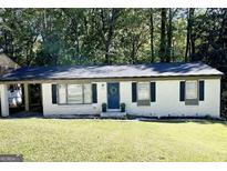 Charming one-story home featuring a beautiful front yard, blue door and an inviting wreath at 859 Kings Grant Nw Dr, Atlanta, GA 30318