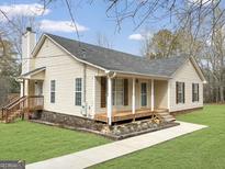 Charming single-story home with a covered front porch, wood shutters and beautiful landscaping at 3725 Concord Rd, Newborn, GA 30056