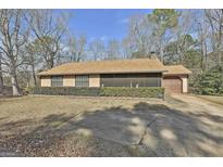 Ranch style home with a screened in porch, driveway, and partial view of the yard at 439 Elder St, Fairburn, GA 30213