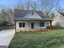 Charming exterior of home with a well-manicured lawn, front porch, and welcoming curb appeal at 5224 W Mountain St, Stone Mountain, GA 30083