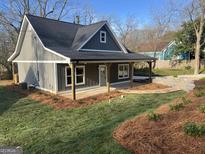Charming gray home featuring a covered front porch and freshly landscaped front yard at 5232 West Mountain Street, Stone Mountain, GA 30083
