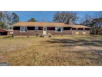 Charming single-story home featuring a long front porch and spacious lawn at 3579 Bill Gardner Pkwy, Locust Grove, GA 30248