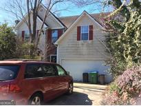 Two story home with attached two car garage, mature landscaping, and a driveway with an automobile at 2054 Gwinn Dr, Norcross, GA 30071