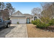 Charming single-story home featuring a two-car garage, stucco exterior, and inviting light blue front door at 306 Preston Chase Dr, Peachtree City, GA 30269