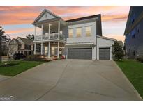 Charming two-story home featuring a double front porch, three-car garage, and a well-manicured lawn at 401 Hallman Pl, Peachtree City, GA 30269