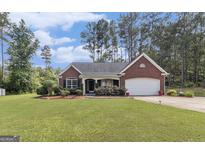 Charming brick home with a well-manicured lawn, landscaping, and an attached two-car garage at 25 Horseshoe Ct, Covington, GA 30014