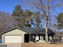 Charming single-story home featuring a stone facade, two-car garage, and a well-maintained front yard at 11157 Ash Ct, Hampton, GA 30228