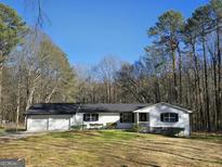 Charming single-story home with attached two-car garage, surrounded by lush trees at 621 Hood Rd, Stockbridge, GA 30281