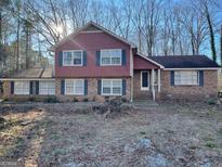 Charming two-story home featuring brick accents, blue shutters, and a well-maintained front yard at 392 N Hwy 314, Fayetteville, GA 30214