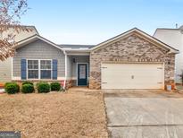 Charming single-Gathering home with a brick facade, blue shutters, and a well-maintained front yard at 184 Parkview Place Dr, Mcdonough, GA 30253