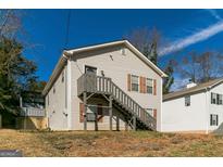 Charming multi-level home with light siding, traditional windows, and stair access to the front door under a clear blue sky at 5365 Renault St, Cumming, GA 30041