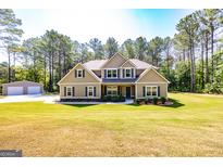 Charming two-story home with a well-maintained lawn and matching detached two car garage at 305 Beavers Rd, Grantville, GA 30220