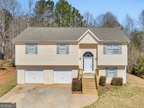 Charming split-level home with a well-maintained lawn and a two-car garage at 195 Brighton Dr, Covington, GA 30016