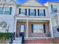 Charming townhouse featuring a brick facade, black shutters and inviting covered entrance at 6206 Flat Trace, South Fulton, GA 30291