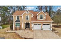 Two-story home with tan siding, brown roof, and a two-car garage at 10175 Point View Dr, Jonesboro, GA 30238